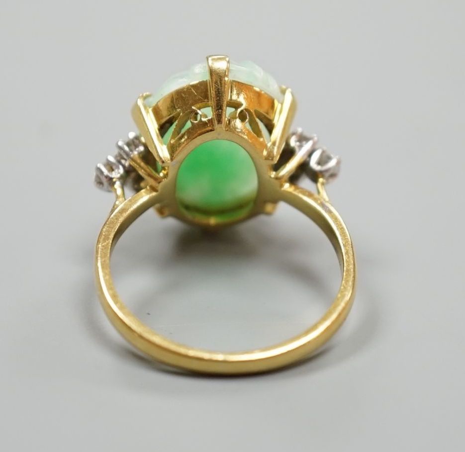 An 18ct, carved jade cabochon and diamond set oval dress ring, size O, gross weight 6.2 grams.